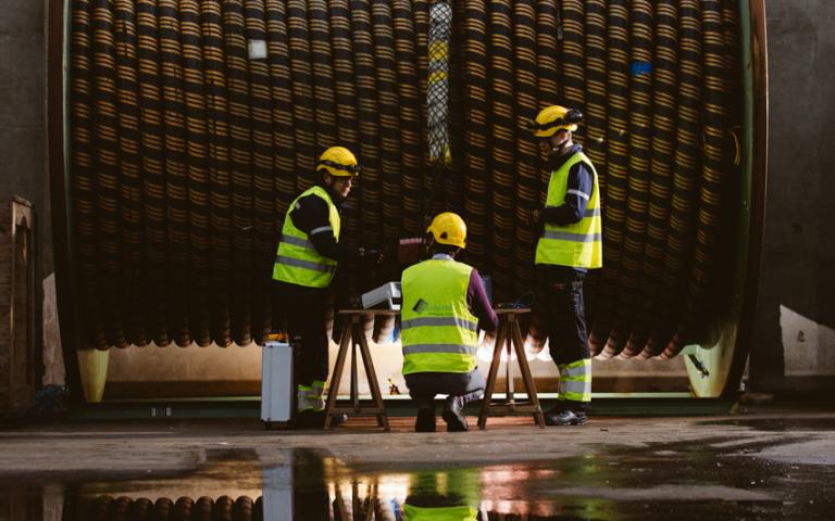 offshore cable on reel with 3 personnel